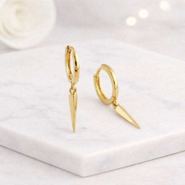 Golds pike hoop earrings in14K solid gold with polished huggie hoops and pointed drop designs how nona cleanmarble surface ideal for minimalist jewelry loverss