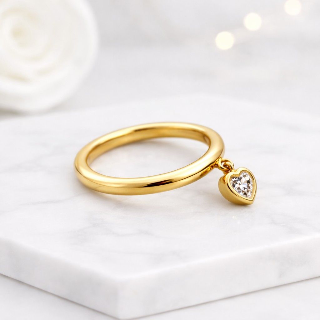 Heart diamond charm ring in solid gold with a floating heart diamond pendant attached to a thin band photo graphed in soft light