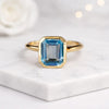 Emerald Cut Blue Topaz Solitaire Ring in 14K Yellow Gold